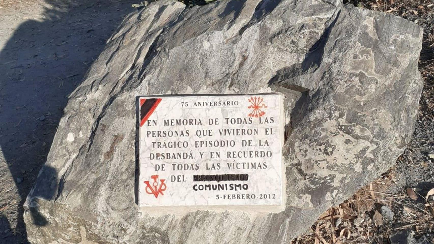 Una placa, con pintadas.