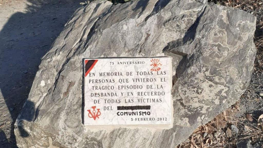 Una placa, con pintadas.