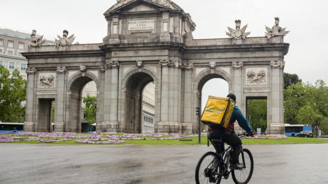 Un 'rider' circulando por los alrededores de la Puerta de Alcalá (Madrid) en mayo de 2020.