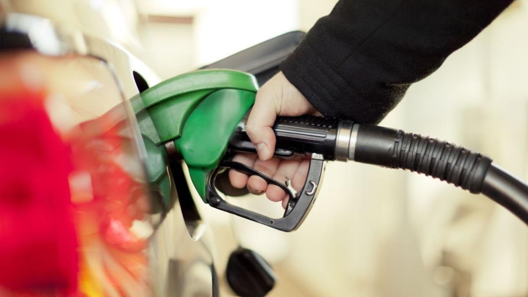 Un hombre repostando en una gasolinera.