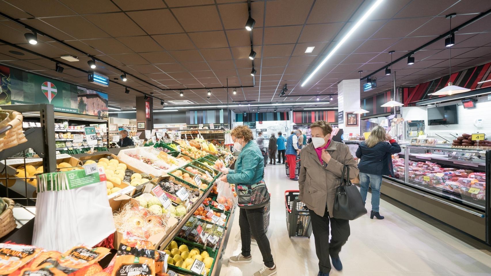 Mujeres observando fruta en un supermercado.