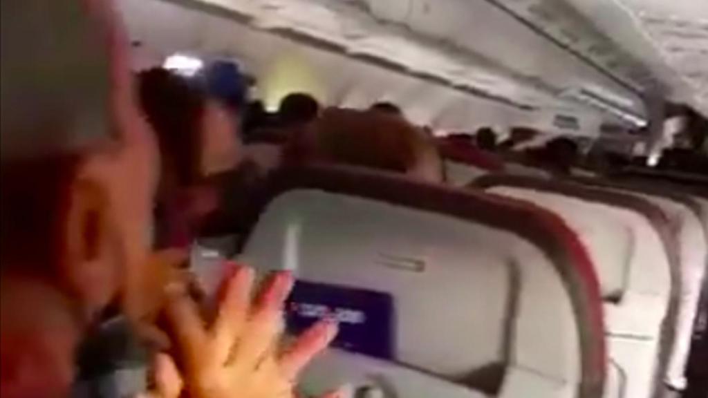 Uno de los pasajeros reza durante en angustioso aterrizaje.