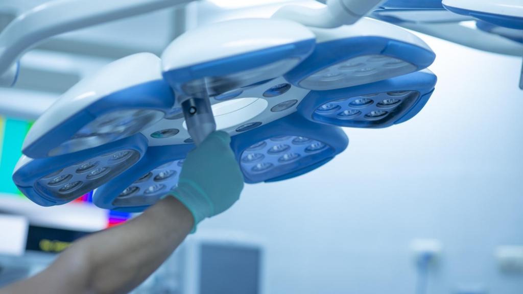 Una enfermera ajusta las luces en un quirófano.