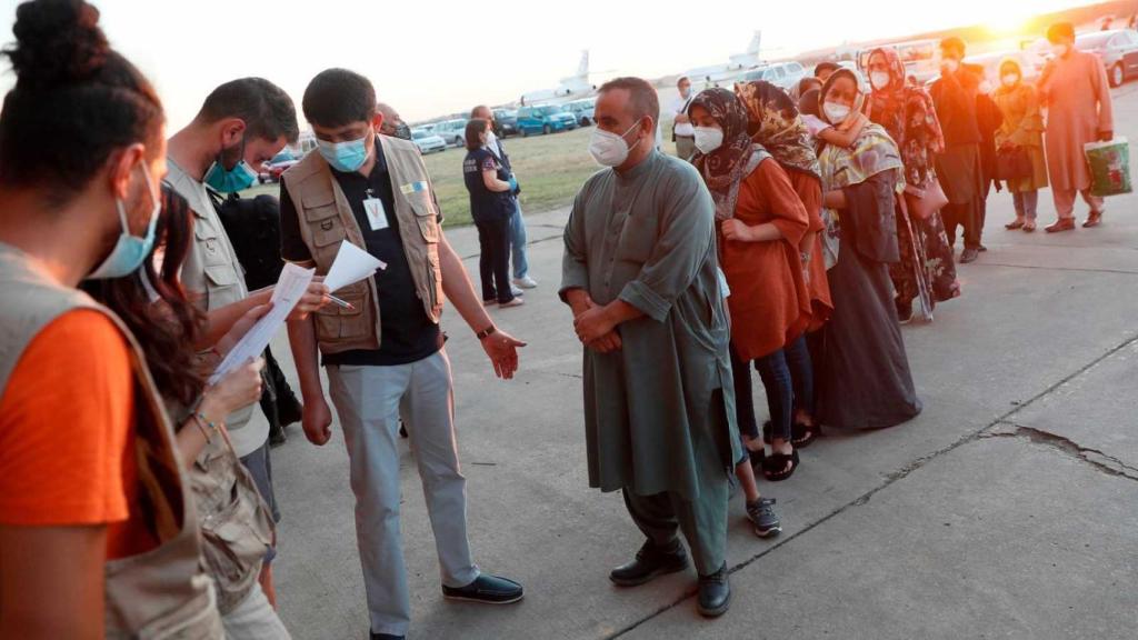Un grupo de afganos hace cola para embarcar en un avión del Ejército español.