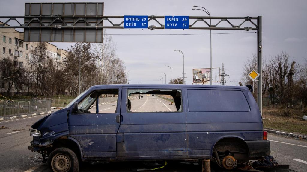 Un vehículo destrozado tapona una de las carreteras de la ciudad.