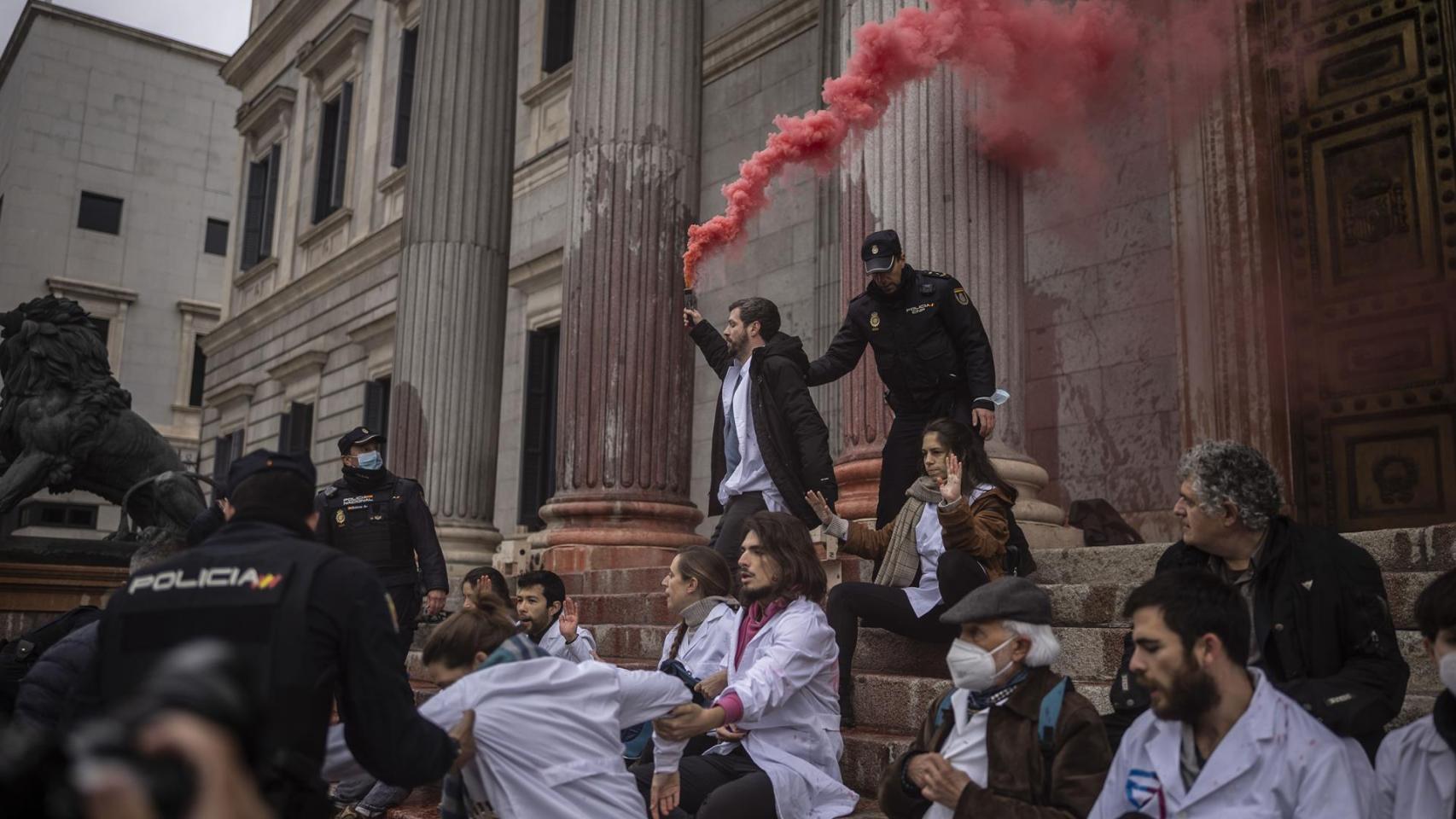 Científicos arrojan jarabe de remolacha en la fachada del Congreso de los Diputados.
