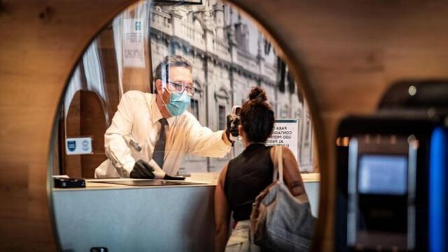 Un hotel tomando la temperatura a un cliente durante la pandemia, en imagen de archivo.