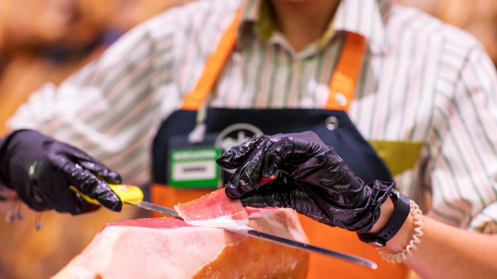 Un empleado de Mercadona corta jamón. EP.