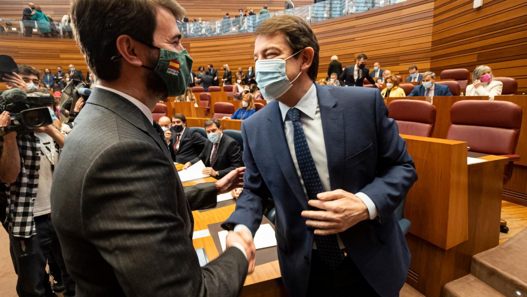 El presidente de la Junta de Castilla y León, Alfonso Fernández Mañueco, estrecha la mano de su nuevo vicepresidente, Juan García-Gallardo.