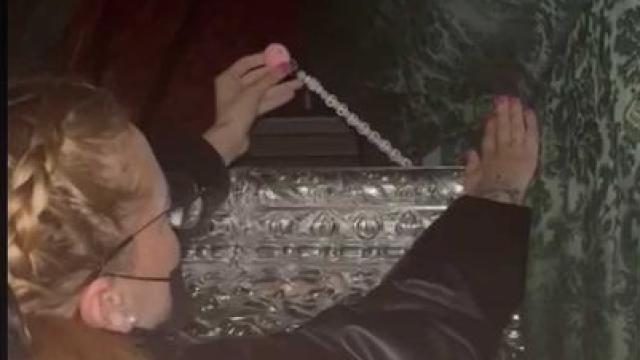 Carmen, la madre de Valentina, colocando el chupetero  bajo el manto de la Virgen de Nueva Esperanza.