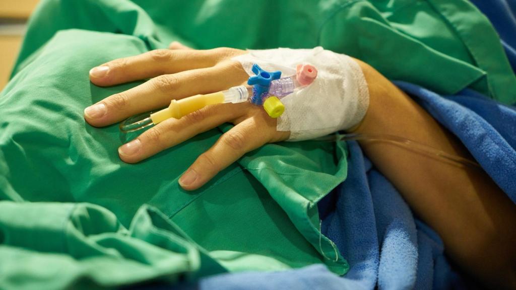 Una paciente espera al doctor en su cama del hospital.