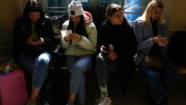 Cuatro jóvenes refugiadas ucranianas descansan en el vestíbulo de la estación de tren de Przemysl Glowny (Polonia) después de huir de la invasión rusa de Ucrania.