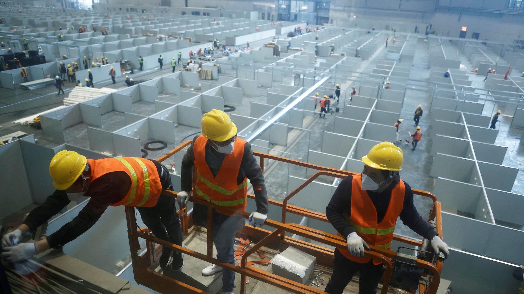 Trabajadores trabajan para convertir el Centro Nacional de Exposiciones de Shanghái, China, en un hospital improvisado por la Covid-19.