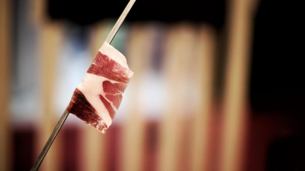 Una loncha de jamón en un cuchillo jamoreno.