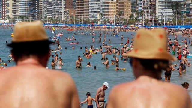 Dos personas observan a los bañistas en la playa de Levante de Benidorm, en imagen de archivo.