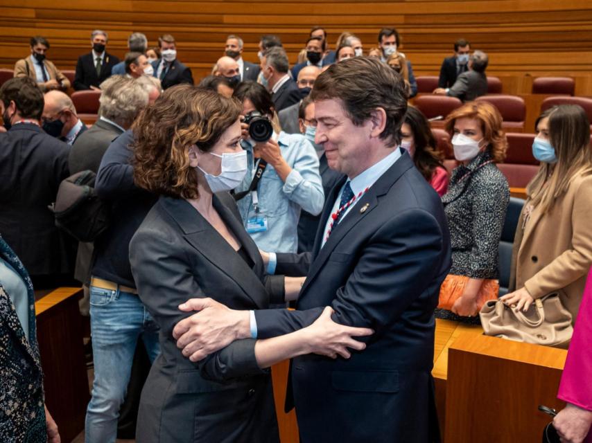 La presidenta de la Comunidad de Madrid, Isabel Díaz Ayuso, saluda al presidente de la Junta, Alfonso Fernández Mañueco, este martes en las Cortes.