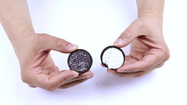 Un joven sostiene una galleta Oreo separada por la mitad.