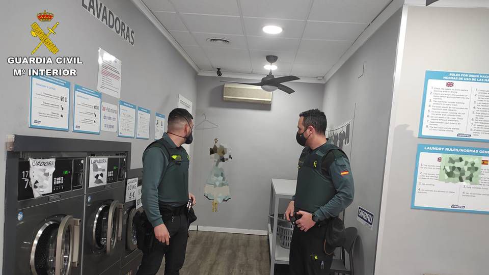 Dos agentes, en una de las lavanderías de autoservicio donde robó el detenido.