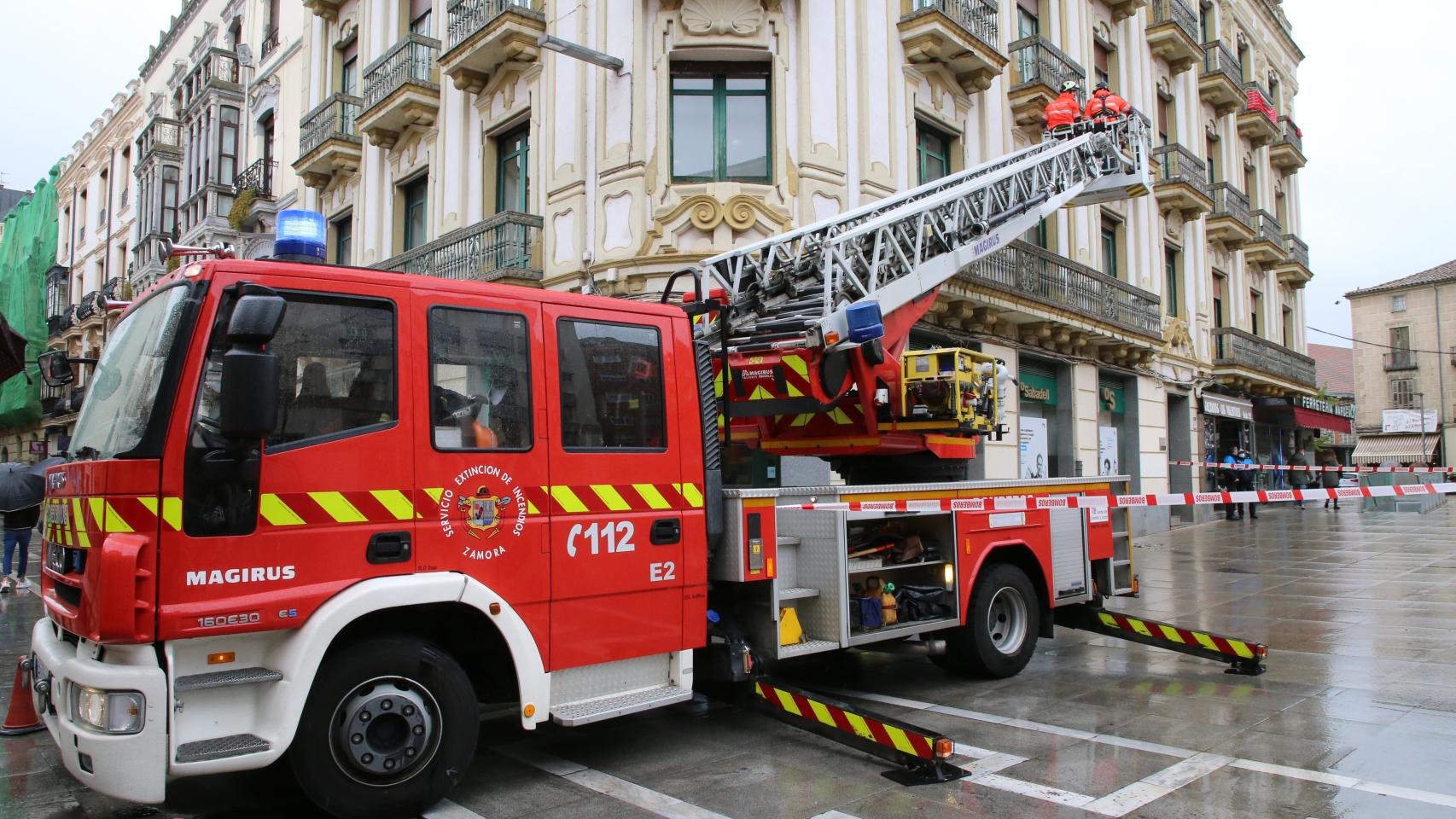 Los bomberos de Zamora retiran elementos que se podrían caer de un balcón en la plaza de la Constitución a causa de la lluvia