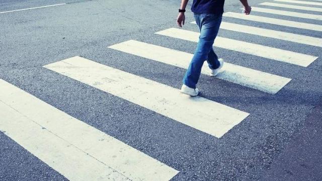 Un hombre cruzando un paso de cebra.