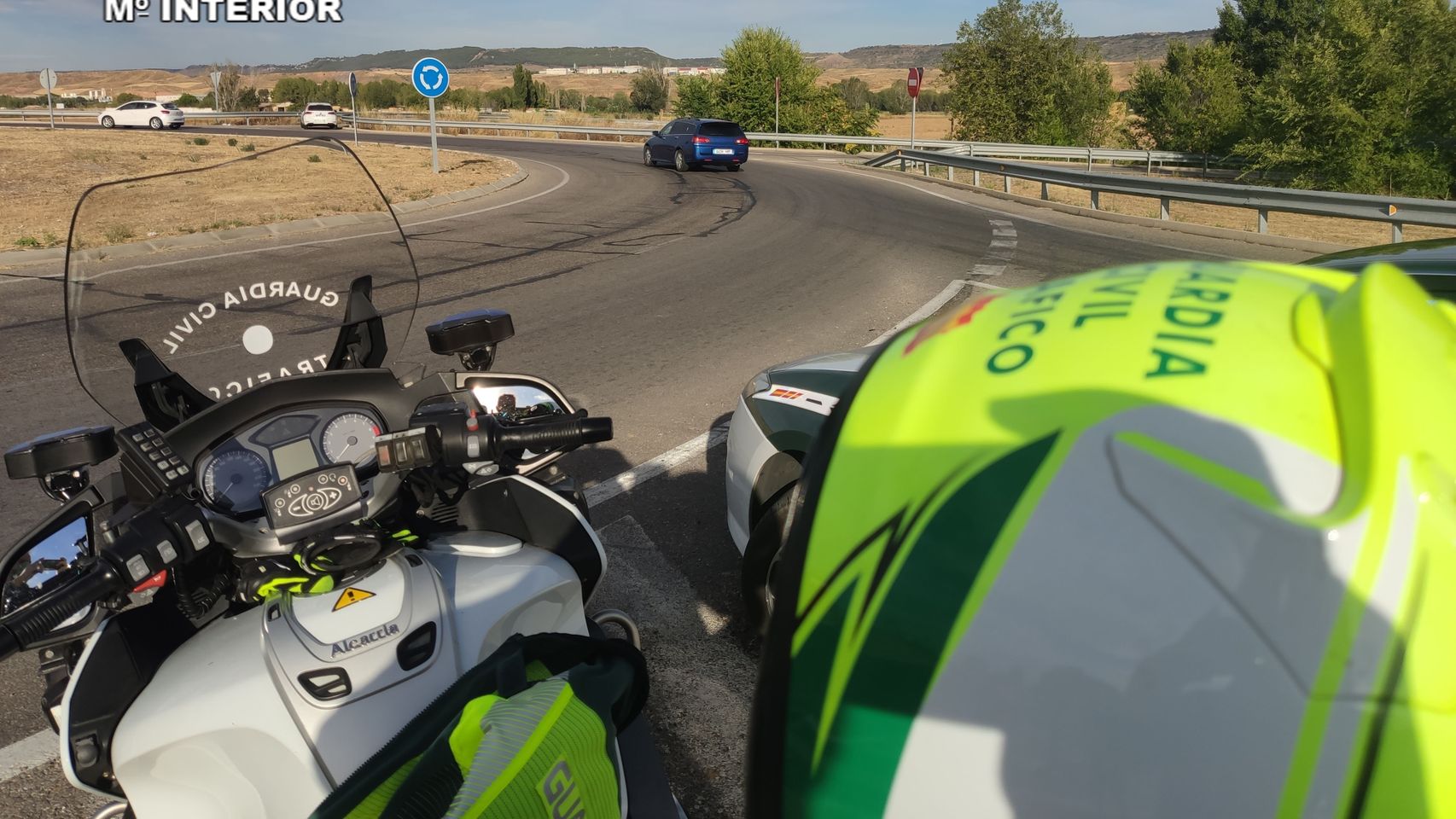 Un motorista de la Guardia Civil de Tráfico junto a una rotonda.