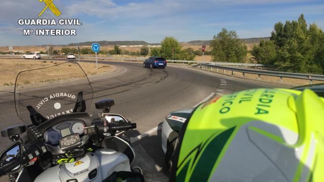 Un motorista de la Guardia Civil de Tráfico junto a una rotonda.