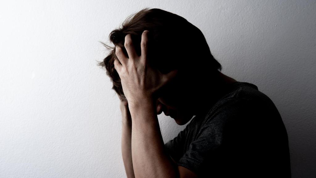 Un señor muy afectado por una migraña.