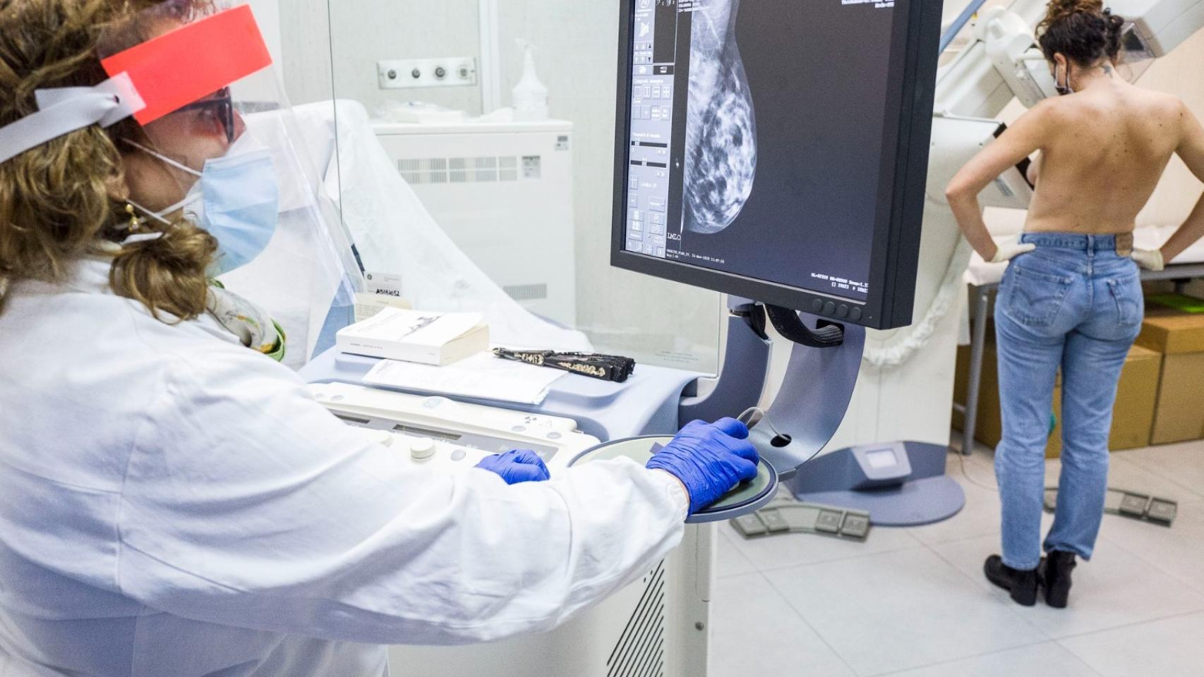 Una médico examina el pecho de una paciente.