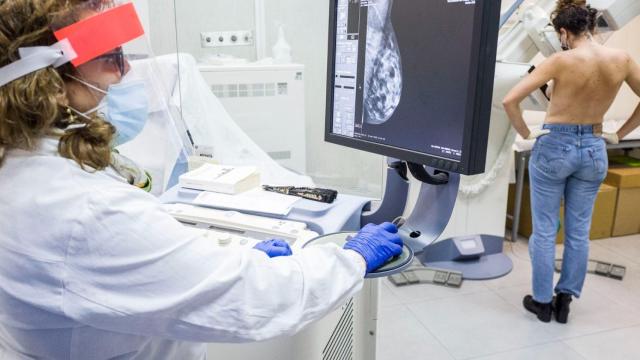 Una médico examina el pecho de una paciente.