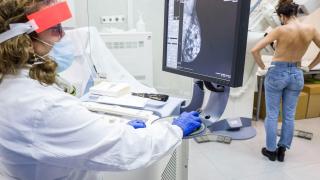 Una médico examina el pecho de una paciente.