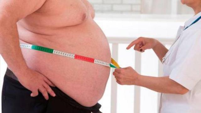 Un doctor mide el diámetro a un paciente.