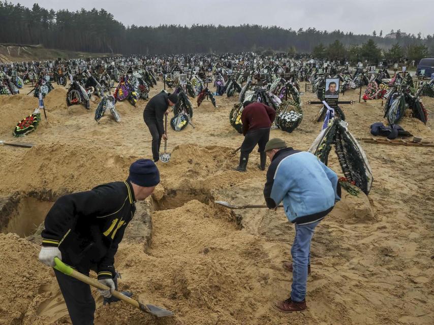 Varias personas entierran a sus muertos en el cementerio de Irpin, Ucrania.