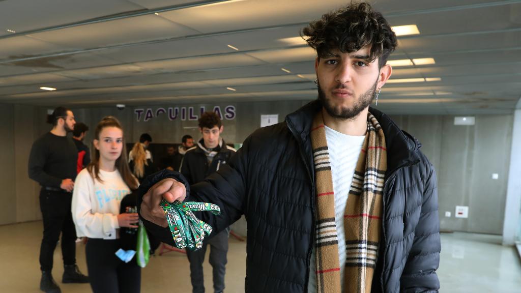 Un joven muestra las entradas de la ITA que acaba de comprar