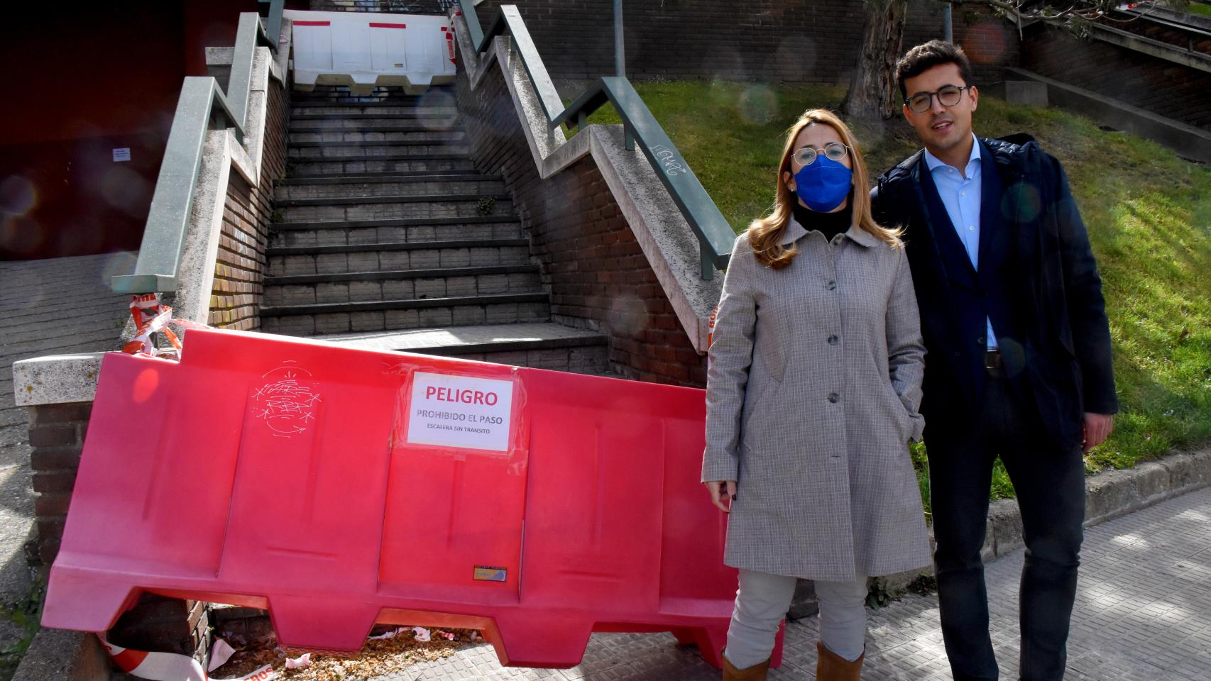 Los concejales del Grupo Municipal Popular, Mayte Martín Pozo y David Ángel García, en las escaleras del Ángel Nieto a La Vaguada