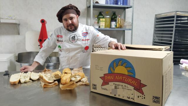 El panadero profesional Julio López, junto a tres barras de pan compradas en los 'chinos'.