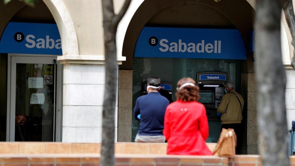 Personas a la espera de ser atendidas en la puerta de un banco, en imagen de archivo.