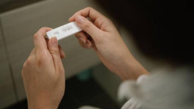 Una mujer ante un test de embarazo.