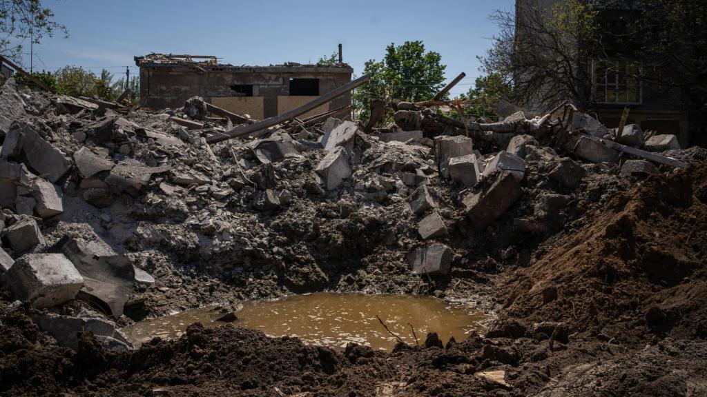 A escasos metros de su casa, el socavón provocado por el impacto del obús.