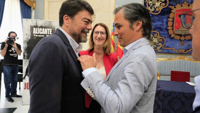 Nacho Lloret charla con el alcalde Luis Barcala bajo la atenta mirada de la edil Mari Carmen de España.