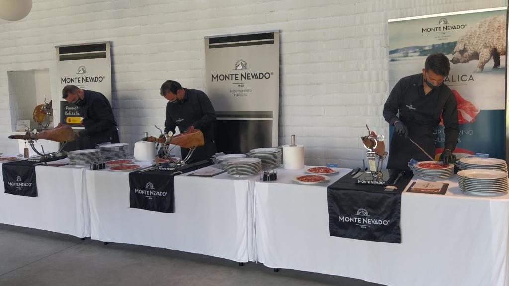 Tres profesionales cortando jamón.