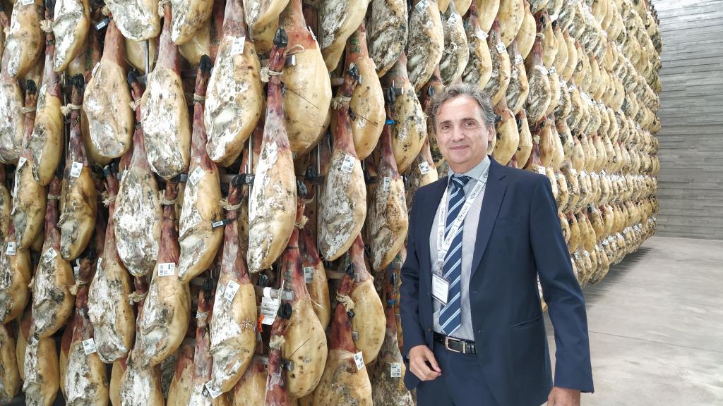 Miguel Olmos, cuarta generación de la familia, ante el millón de jamones de la bodega contigua al campus.
