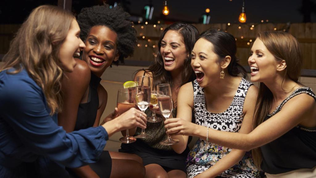 Un grupo de amigas en una cena brindando.