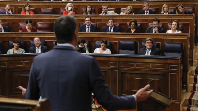 Pedro Sánchez, de espaldas, responde a Cuca Gamarra, portavoz del PP, en la sesión de control.