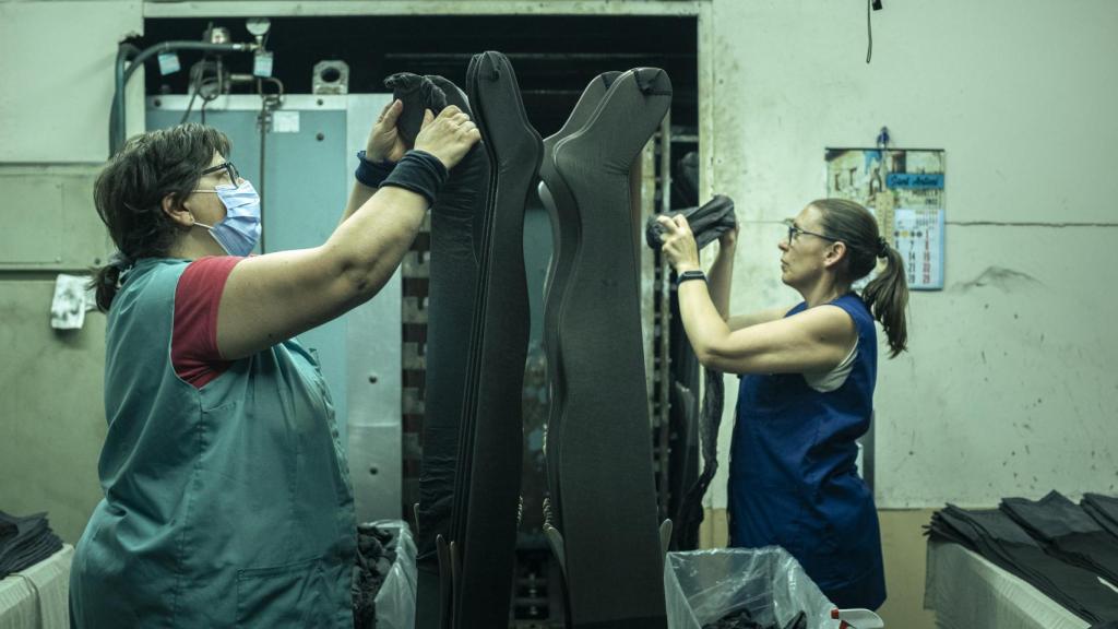 Dos trabajadoras, en la zona de planchado manual de las medias.