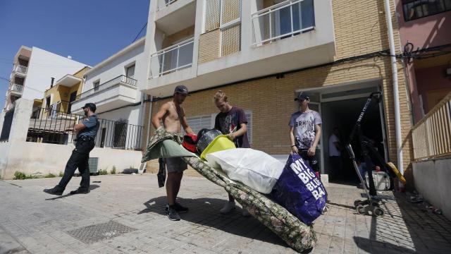 Moradores desalojando el edificio con sus pertenencias, este viernes por la mañana.