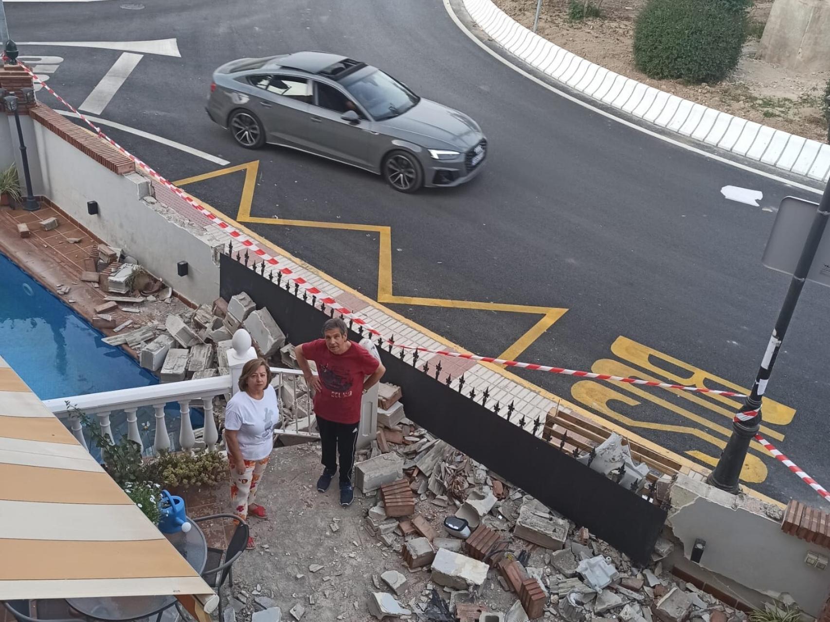 Juan, y su esposa, María Angustias, junto a la valla perimetral que arrasó un turismo que circulaba por la rotonda que hay junto a su casa en la localidad granadina de Atarfe.