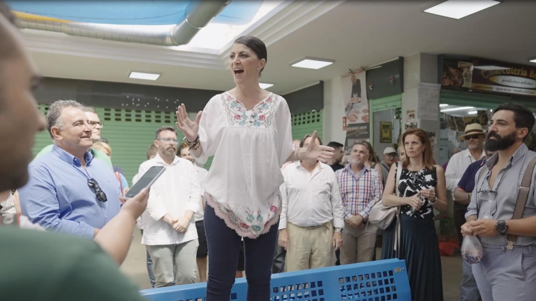 Macarena Olona dando un 'mitin' sobre los bancos del Mercado de Salobreña.