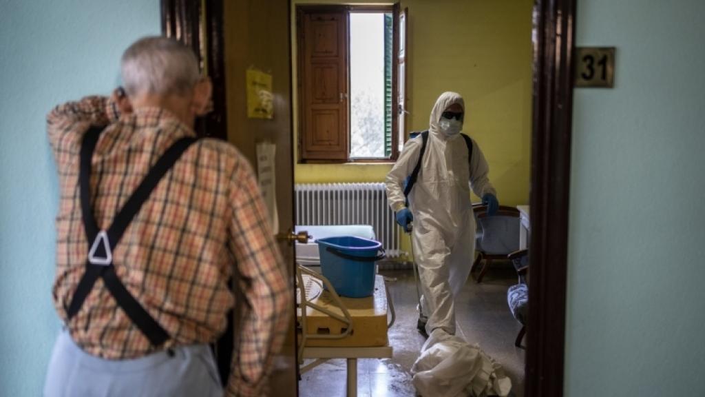 Un anciano espera en el marco de su habitación mientras la desinfectan, en una residencia.