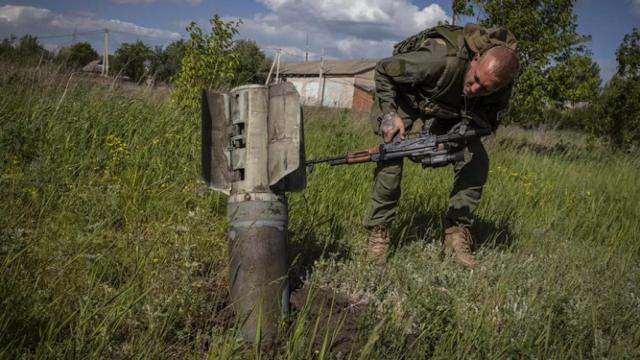 Un soldado ucraniano junto a un misil ruso sin detonar.