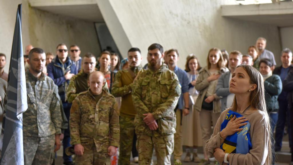 La esposa de un soldado ucraniano asiste a su funeral junto a los compañeros del fallecido este sábado en Kiev
